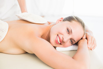 Obraz na płótnie Canvas Peaceful blonde enjoying an exfoliating back massage