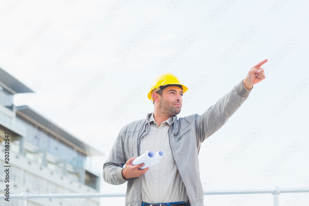 Aufkleber architect with blueprints pointing towards sky