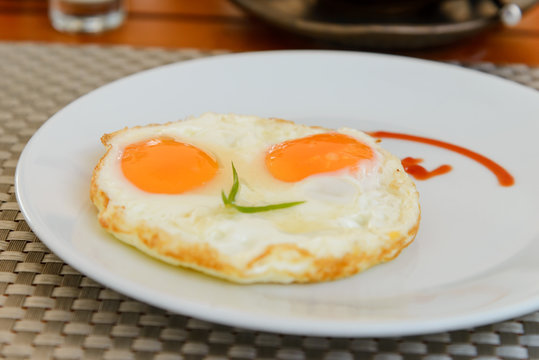 Traditional breakfast fried eggs on white dish