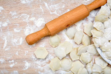 Fototapeta na wymiar Process of making ravioli, pelmeni or dumplings with meat on wooden table