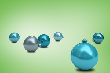 Digitally generated blue christmas baubles against green vignette