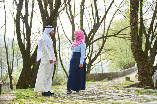 Muslim couple walking by the river