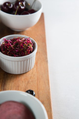 Close-up of cherries with leaf vegetable in bowls