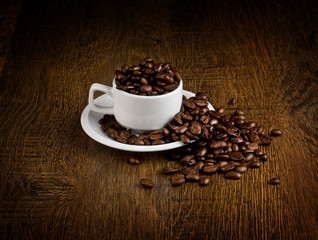 Cup of coffee full of coffee beans.