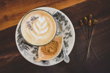 Late art coffee cup on wooden table