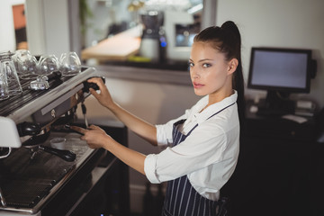 Fototapeta na wymiar Waitress preparing espresso at restaurant