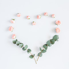 Flowers composition. Heart symbol made of rose flowers, eucalyptus branches on pastel gray background. Flat lay, top view, copy space, square © Flaffy