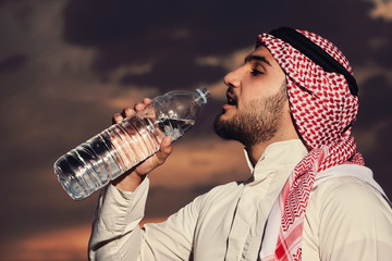 Muslim drinking water at sunset