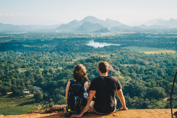 Pärchen sitzt auf einem Berg in Sri Lanka und schaut in die Ferne