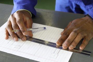 Man practicing to draw electrical diagram at trade school