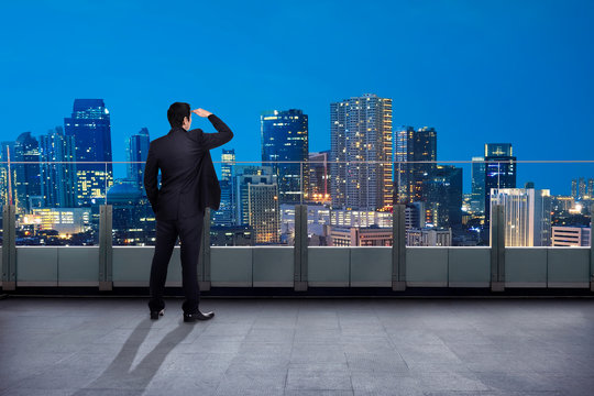 Portrait of asian businessman looking out the city in the balcony