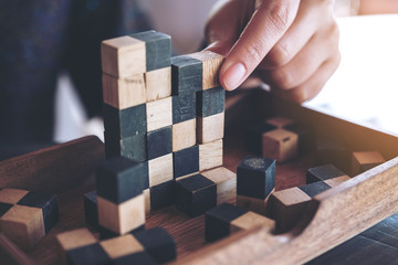 Closeup image of people playing and building wooden puzzle game