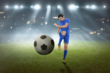 Young asian football player shooting the ball