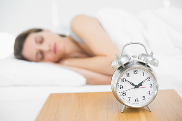 Peaceful young woman lying under the cover on her bed