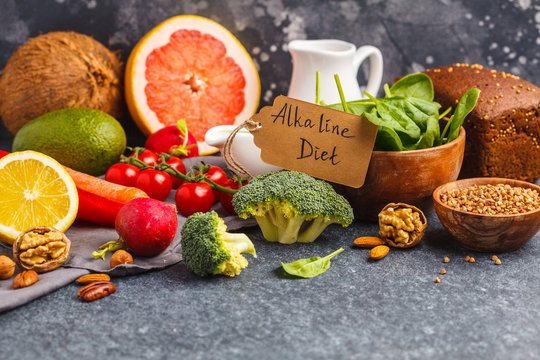 Healthy food background, trendy Alkaline diet products - fruits, vegetables, cereals, nuts, oil, dark background