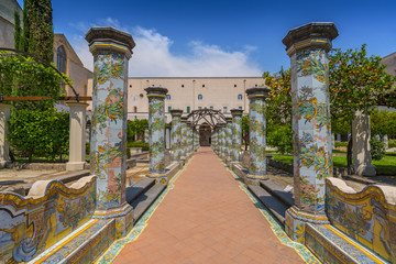 Sunny cloister of the Clarisses decorated with majolica tiles from Santa Chiara Monastery in Naples, Italy.