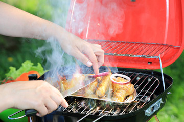 Grilowanie udka z kurczaka, nakładanie plasterków czerwonej cebuli, gril turystyczny. © Stanisław Błachowicz