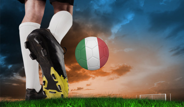 Composite image of football boot kicking italy ball against green grass under blue and orange sky