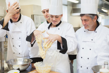 Teacher showing her students how to mix dough