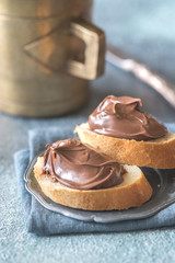 Slices of baguette with chocolate cream on the saucer