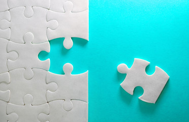 Close up piece of the white jigsaw puzzle , concept of business challenge completion with teamwork
