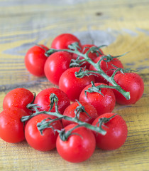 Bunch of fresh cherry tomatoes on the wooden table
