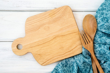  chopping board and tablecloth with the wooden fork and spoon on white table , recipes food  for healthy habits shot note background concept
