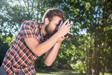 Handsome hipster using vintage camera