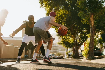 Fotobehang Men playing basketball on street © Jacob Lund