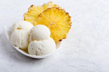 Vanilla ice cream scoops with pineapple chips