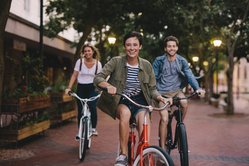 Young friends cycling in the city - obrazy, fototapety, plakaty