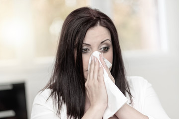 Portrait of woman blowing her nose