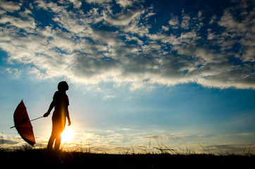 Silhouette of a woman standing holding an umbrella in the evening alone with loneliness.