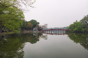 Fototapeta na wymiar Beautiful view of the Huc Bridge leads to Ngoc Son Temple on a small island (Original built in 1841), Hoan Kiem Lake, Hanoi, Vietnam