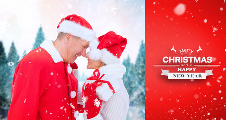 festive mature couple holding gift against red vignette