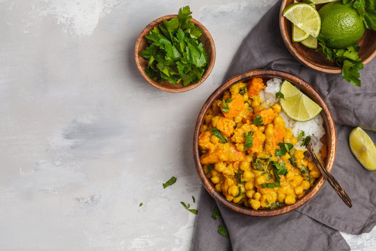Vegan Sweet Potato Chickpea curry in wooden bowl on a light background, top view. Healthy vegetarian food concept.
