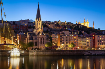 Illuminated Passerelle Saint Georges footbridge and Vieux Lyon in Lyon, France, at dusk.