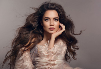 Fashion studio photo of gorgeous sexy brunette woman with long healthy hair and evening makeup posing with pink fur coat isolated on gray background. Fashionable girl portrait. Vogue style. - 202908786