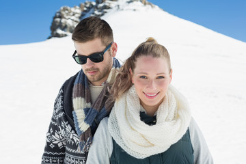 Fototapeta na wymiar Couple in warm clothing in front of snowed hill