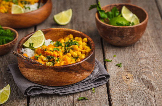 Vegan Sweet Potato Chickpea curry in wooden bowl on a wooden background. Healthy vegetarian food concept.