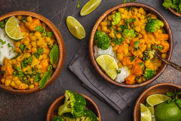 Vegan Sweet Potato Chickpea curry in wooden bowl on a dark background, top view. Healthy vegetarian food concept.