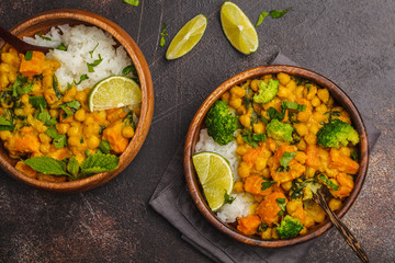 Vegan Sweet Potato Chickpea curry in wooden bowl on a dark background, top view. Healthy vegetarian food concept.