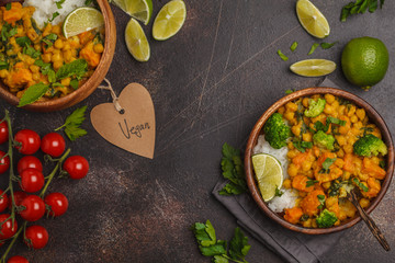 Vegan Sweet Potato Chickpea curry in wooden bowl on a dark background, top view, copy space. Healthy vegan food concept.