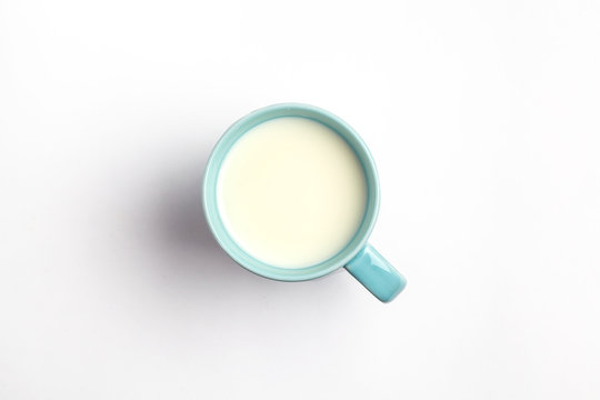 Milk in a blue mug isolated on a white background, top view.