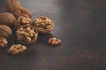 Walnut in a shell on a dark concrete background, copy space. Healthy vegetable diet concept..