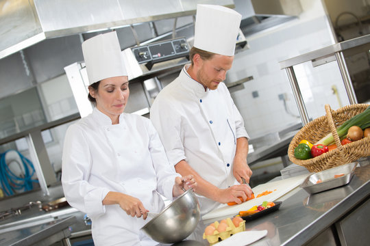 two chefs preparing in a restaurant kitchen
