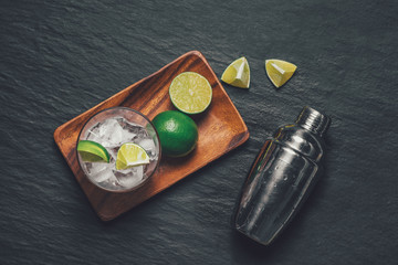 Mojito cocktail with lime and mint on dark stone table