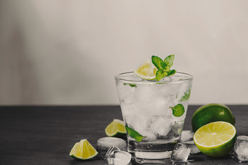Mojito cocktail with lime and mint in glass on a grey stone background