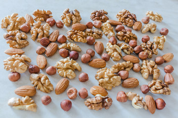 Mix of spilled almond, walnuts and hazelnuts close-up, selective focus