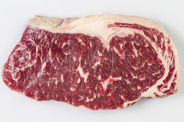 Ripened seasoned beef rump or striploin steak on white background isolated. Yop view.